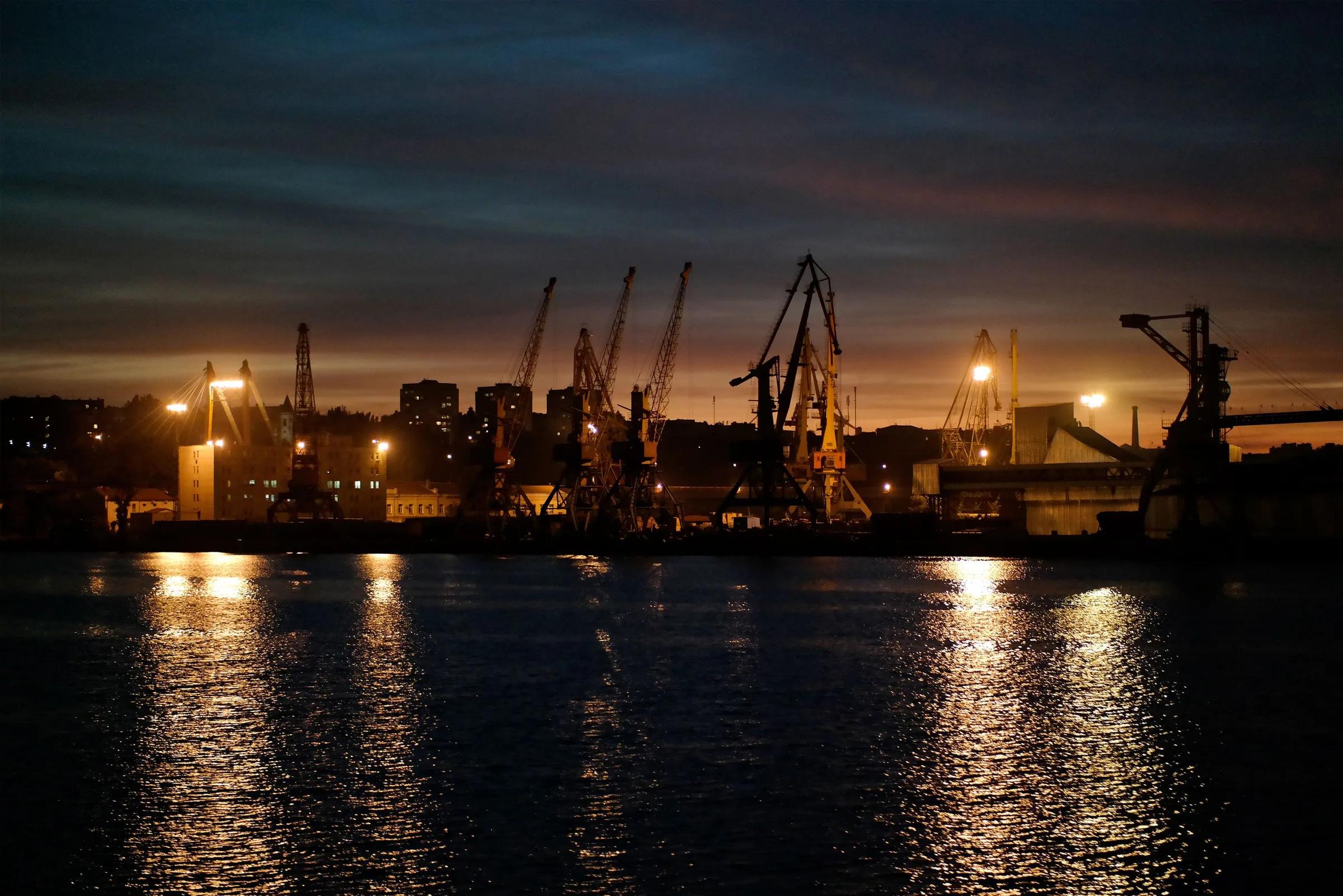 Grues portuaires illuminées à la tombée de la nuit